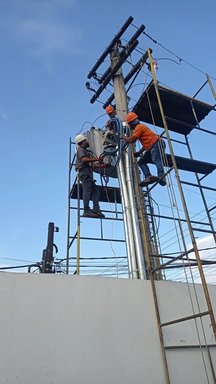 Equipe em poste de alta tensão